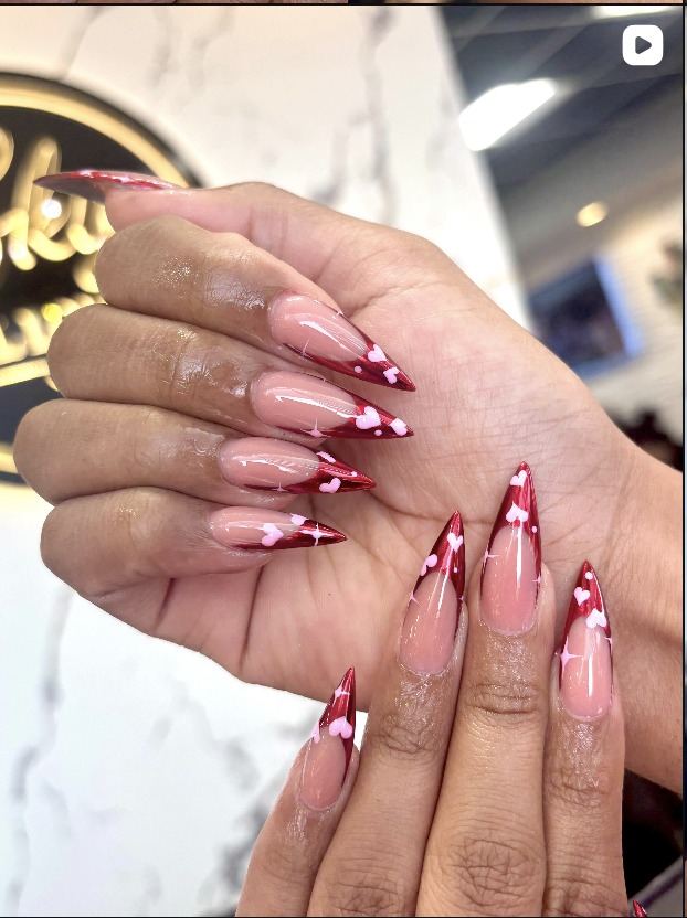 Red stiletto nails with heart accents